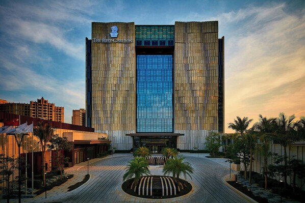 A modern hotel with a prominent entrance, a central fountain, and a symmetrical facade.