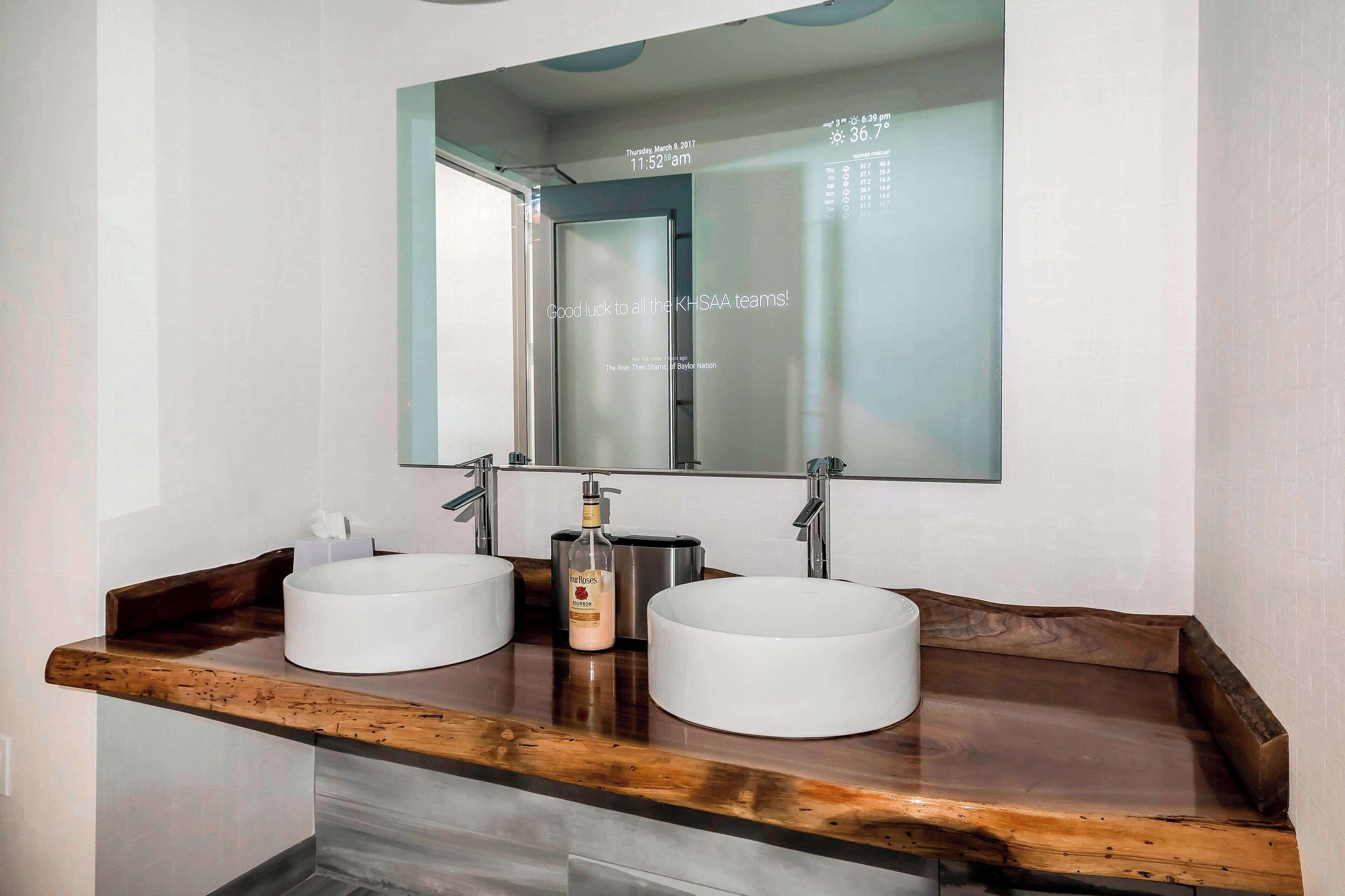 Un baño con dos lavamanos, un espejo y una encimera de madera.
