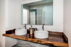 Un baño con dos lavamanos, un espejo y una encimera de madera.