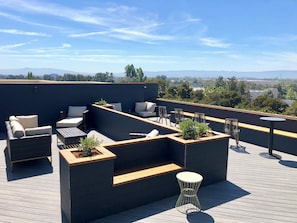 A rooftop terrace with outdoor seating, a small table, and planters. - Holiday Inn & Suites Silicon Valley - Milpitas by IHG (Milpitas)