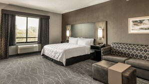 A modern hotel room with a large bed, a sofa, a small table, and a large window with curtains. - Holiday Inn & Suites Silicon Valley - Milpitas by IHG (Milpitas)
