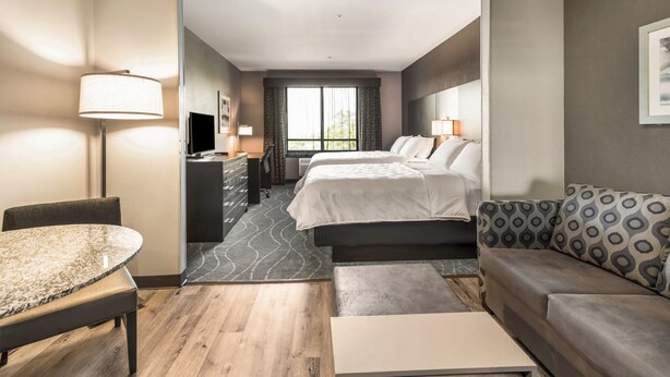 A hotel room with a bed, a sofa, a desk, and a TV. - Holiday Inn & Suites Silicon Valley - Milpitas by IHG (Milpitas)