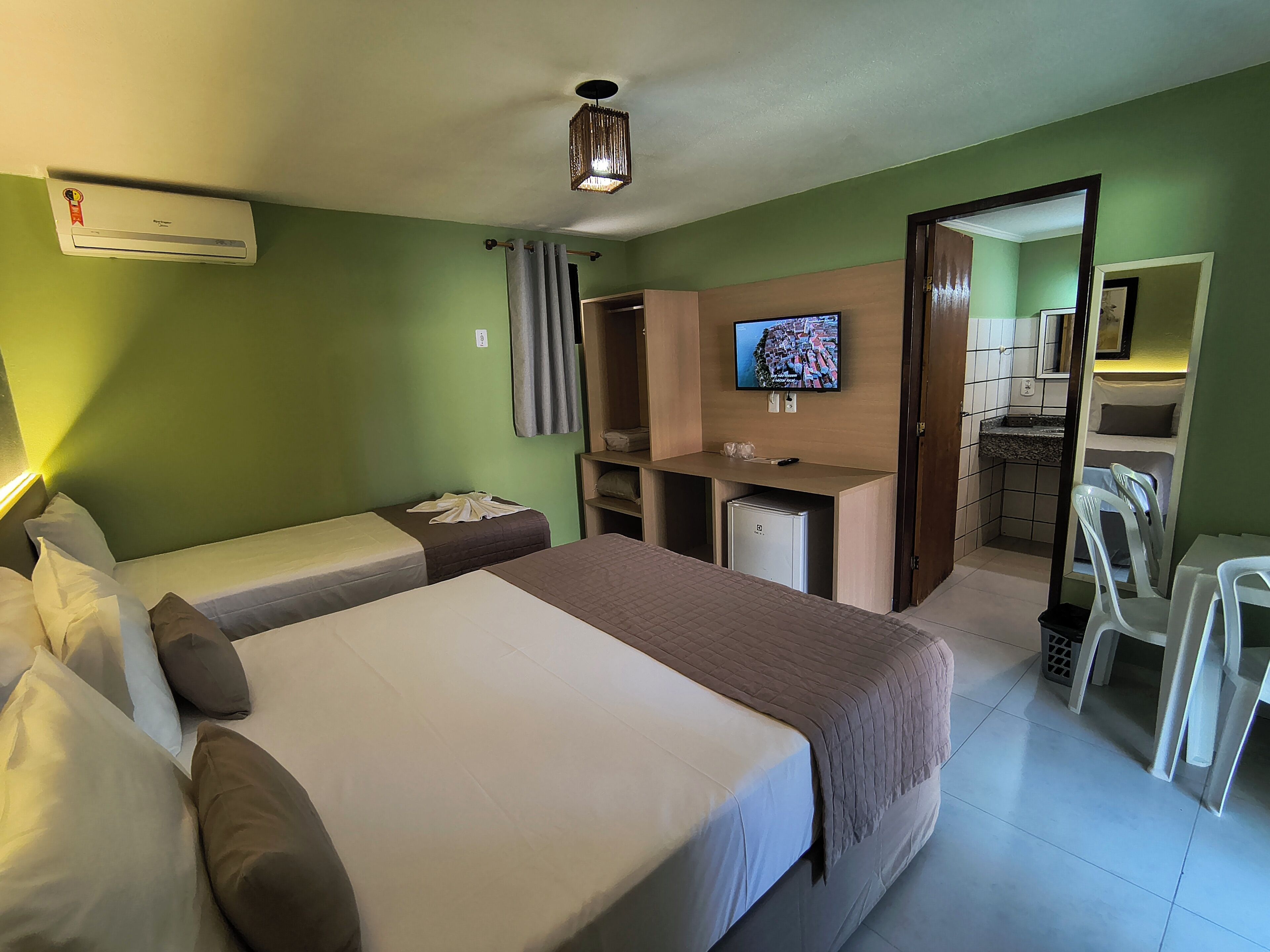 Une chambre d’hôtel équipée d’un lit, d’un bureau, d’une télévision et d’une kitchenette.