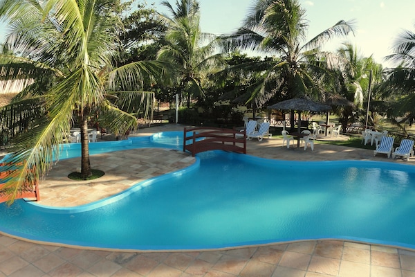 Een buitenzwembad, parasols voor strand/zwembad