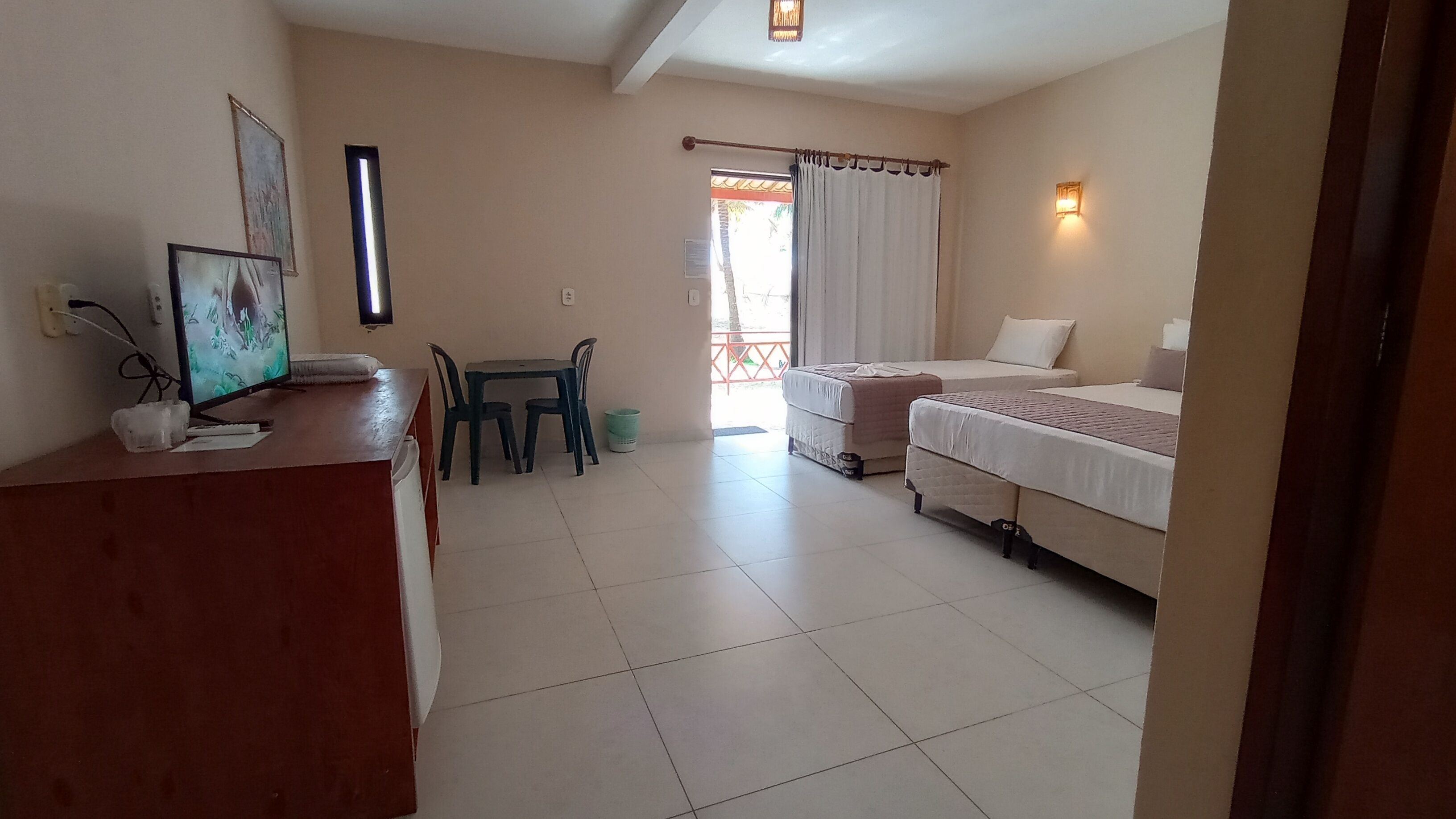 Une chambre d’hôtel avec deux lits, un bureau avec un ordinateur, une chaise et une petite table.