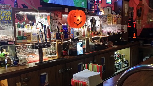 A bar area with various liquor bottles, a beer tap, and a sign for a 25 cent price. - Tahitian Motor Inn (Pasco)