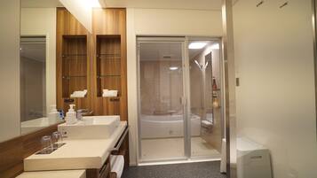A modern bathroom with a glass-enclosed shower, a large mirror, and a vanity with a countertop.