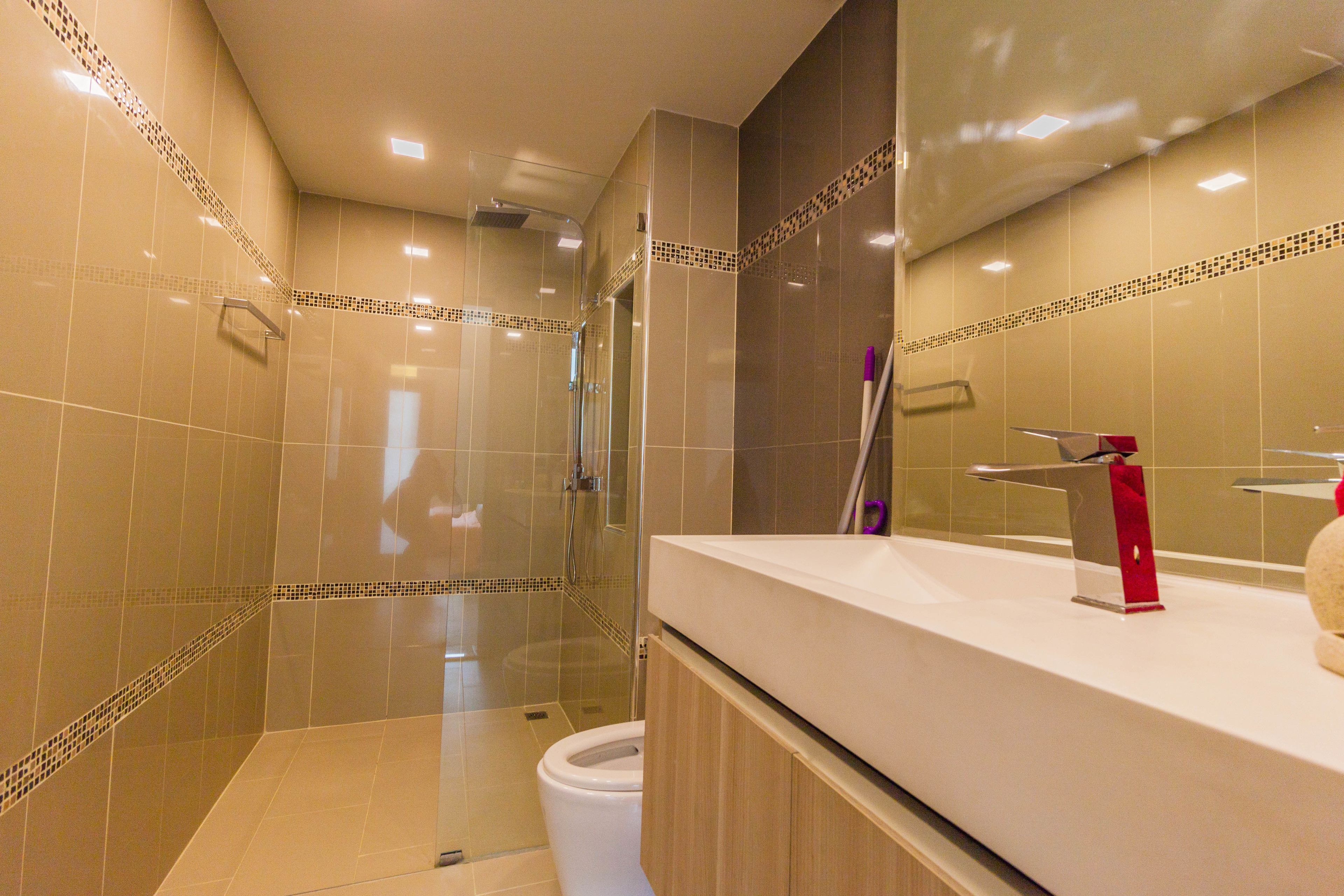 A modern bathroom with a shower, toilet, and vanity.