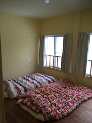 Cozy retreat with a single bed, bedspread, and window with curtains.