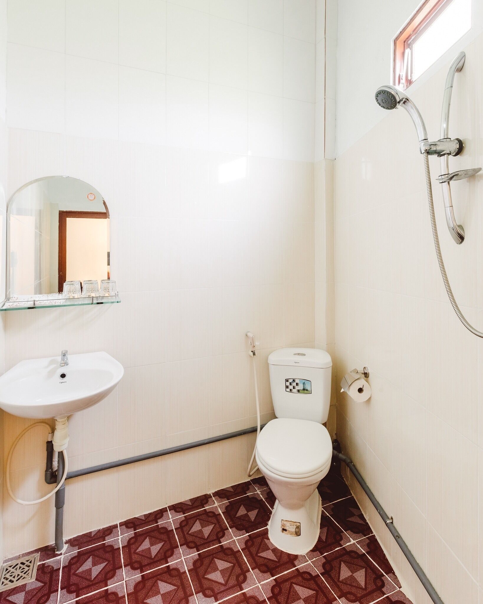 Un baño pequeño con un lavabo blanco, un inodoro y una ducha.