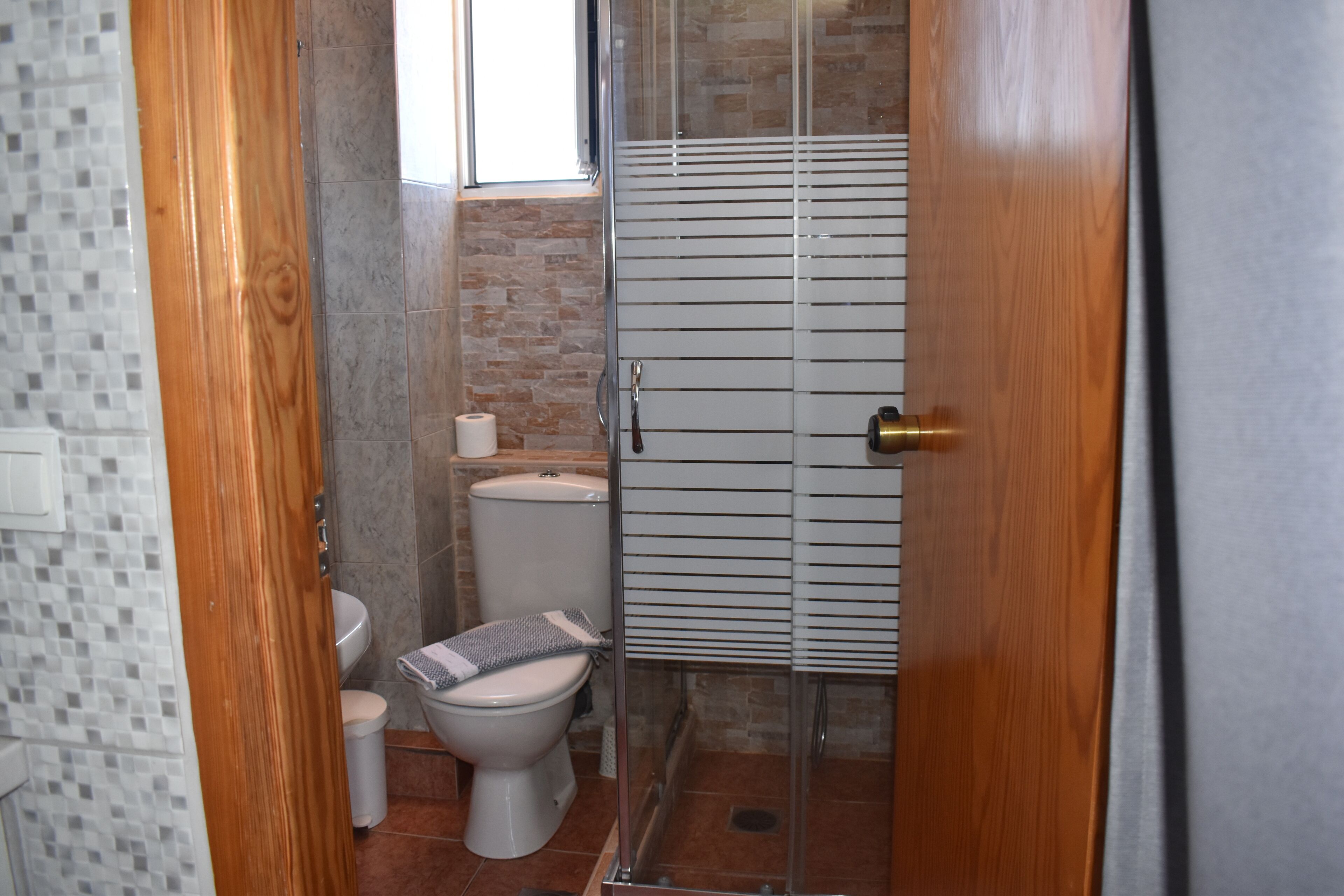 Een badkamer met toilet, wastafel en douche.