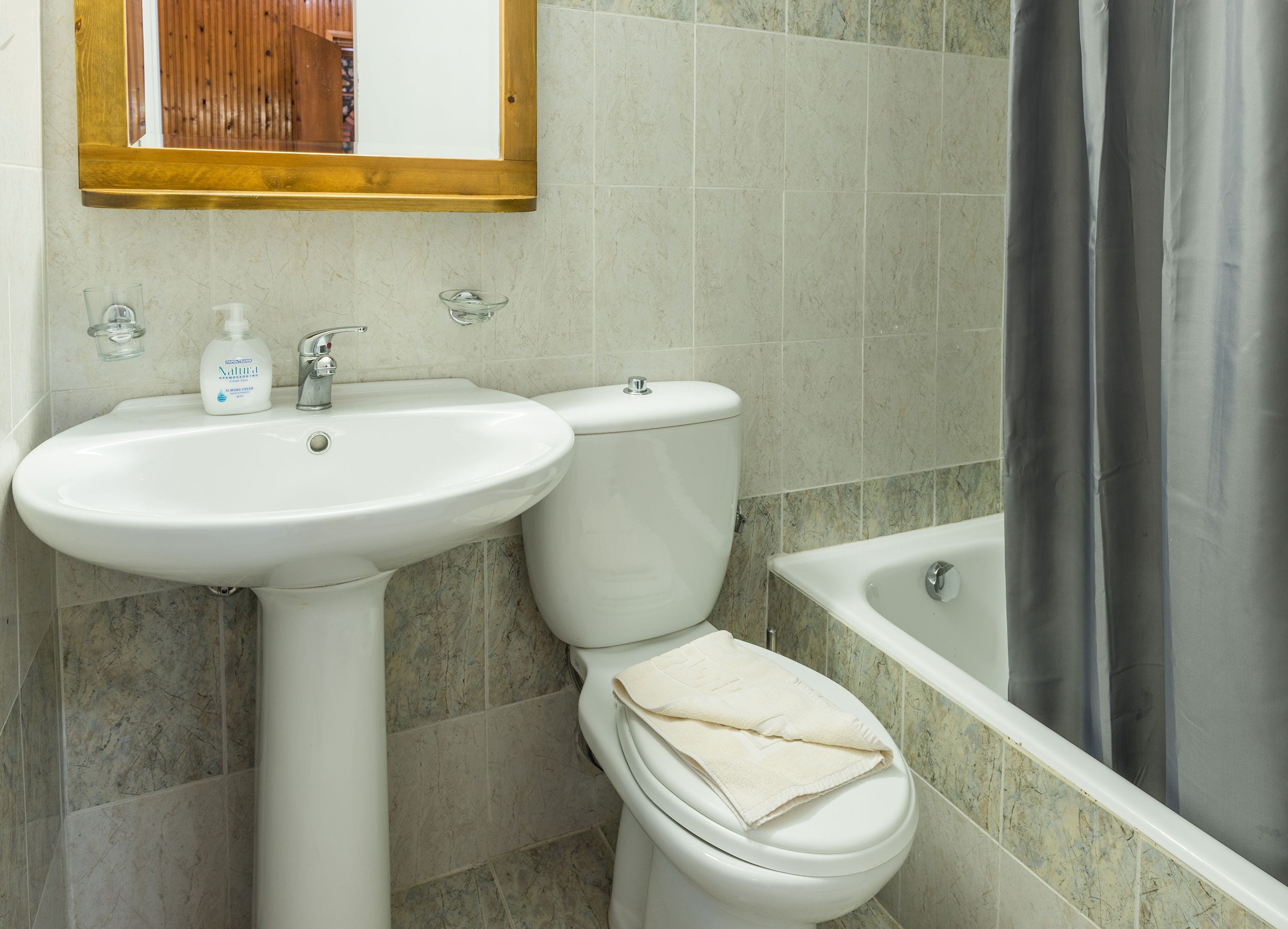 A bathroom with a white sink, toilet, and bathtub.