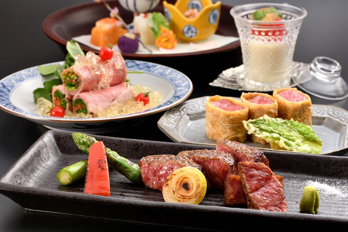 A variety of dishes including steak, asparagus, and a dessert plate.
