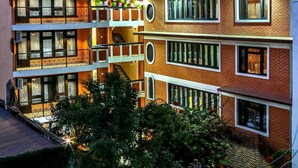 Un edificio de varios pisos con balcones, ventanas y una terraza en la azotea.