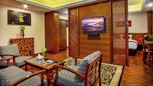 Una sala de estar moderna con televisor, muebles con diseño y un separador decorativo.