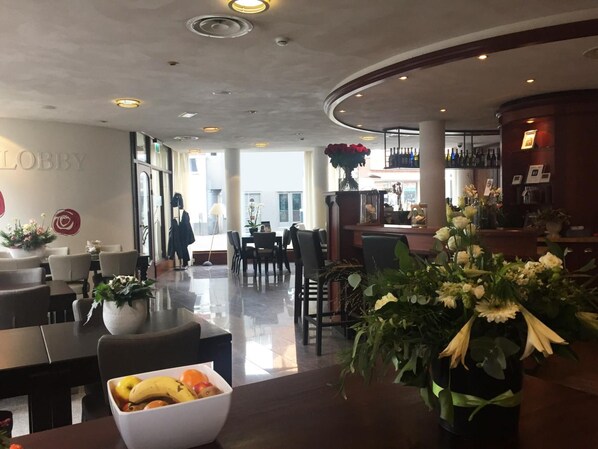 A lobby with a reception desk, seating area, and a bar. - Hotel Tongerlo (Roosendaal)