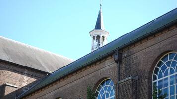 A brick building with arched windows and a tower with a cross on top.