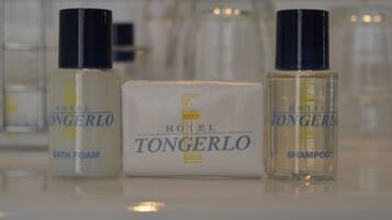 Três frascos de produtos de banho do Hotel Tongero: espuma de banho, shampoo e uma caixa da marca do hotel.