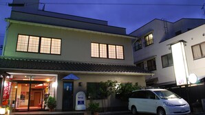 A two-story building with a traditional Japanese architectural style, featuring a storefront with glass doors and a signboard. - Hanagoyomi (Nanao)