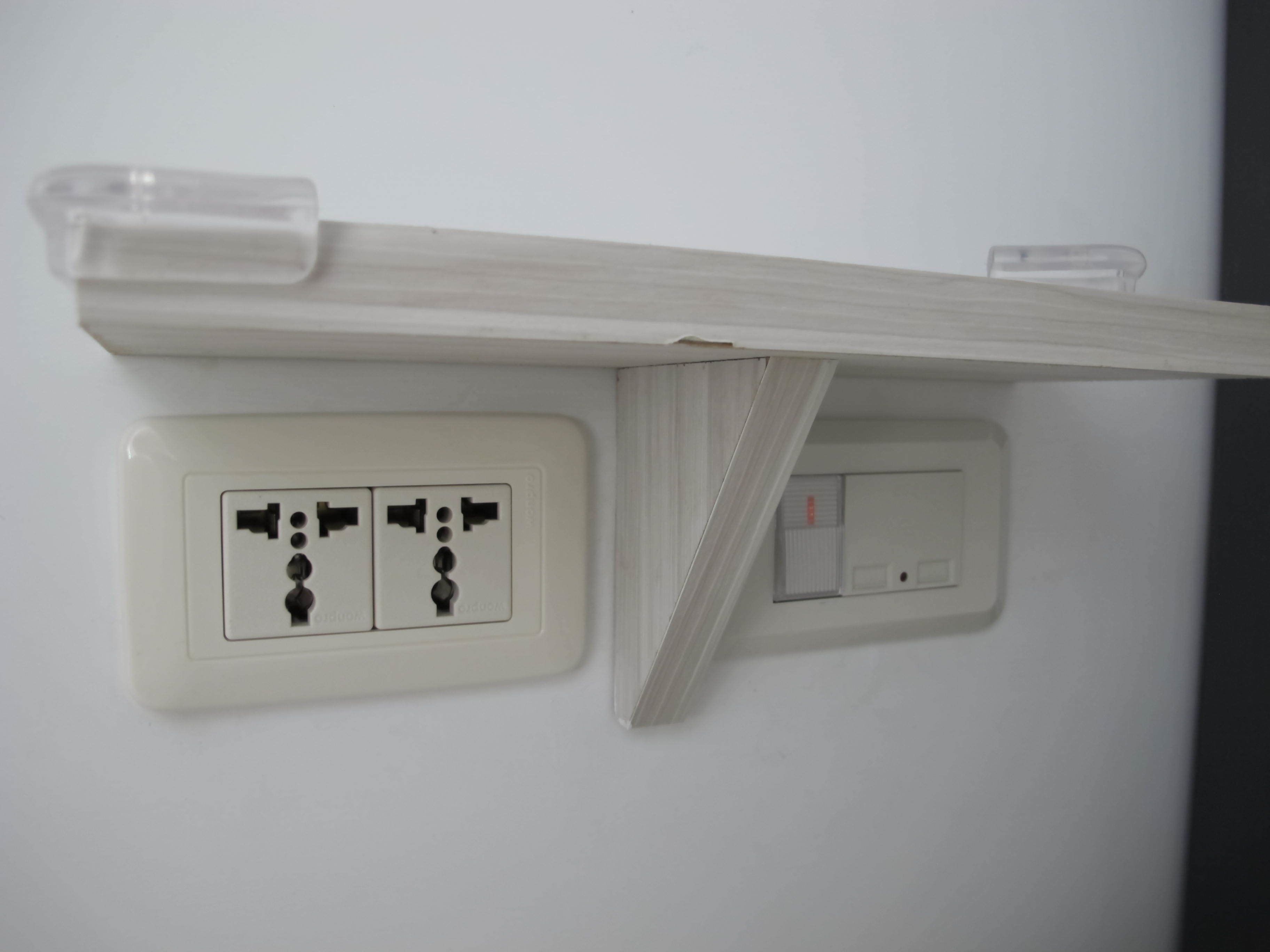 A wall-mounted electrical outlet with a switch and a socket.