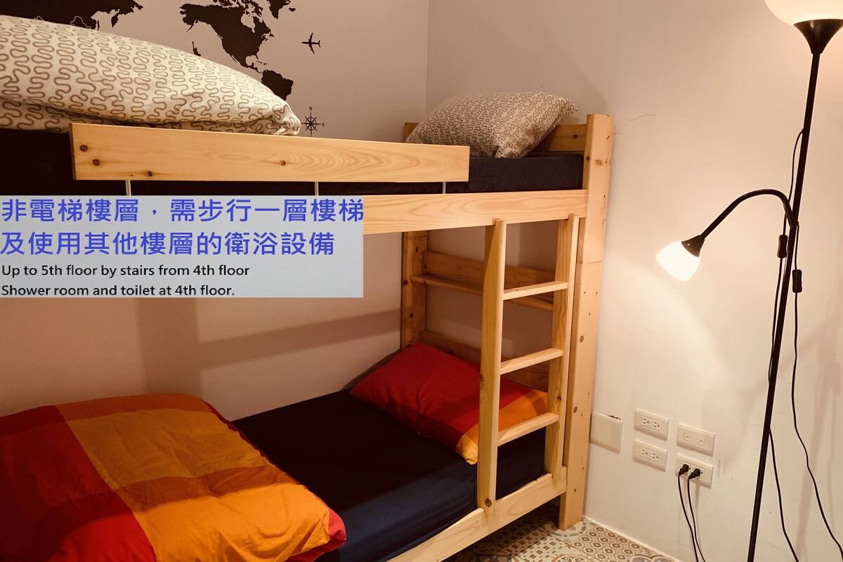 A bunk bed room with a wooden ladder, a globe wall decal, and a lamp.