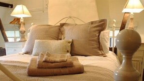 A bed with a headboard, pillows, and a folded blanket. - Riverside House (Norwich)