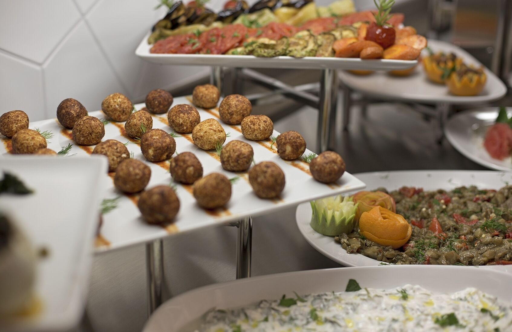 Ein Buffet mit verschiedenen Gerichten, darunter Klöße, Salate und ein Gemüsegericht.