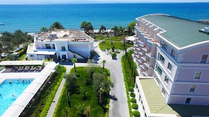 A resort with a swimming pool, a well-maintained garden, and a view of the sea. - Rawda Resort Hotel Altinoluk (Edremit)