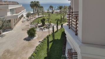 A balcony with a view of a beach and palm trees.
