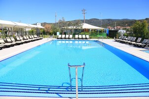 Una piscina al aire libre de temporada, sombrillas