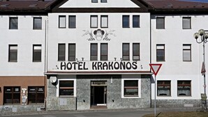 Un hotel llamado 'HOTEL KRAKONOS' con un estilo arquitectónico tradicional, que cuenta con una entrada destacada y una señalización clara.