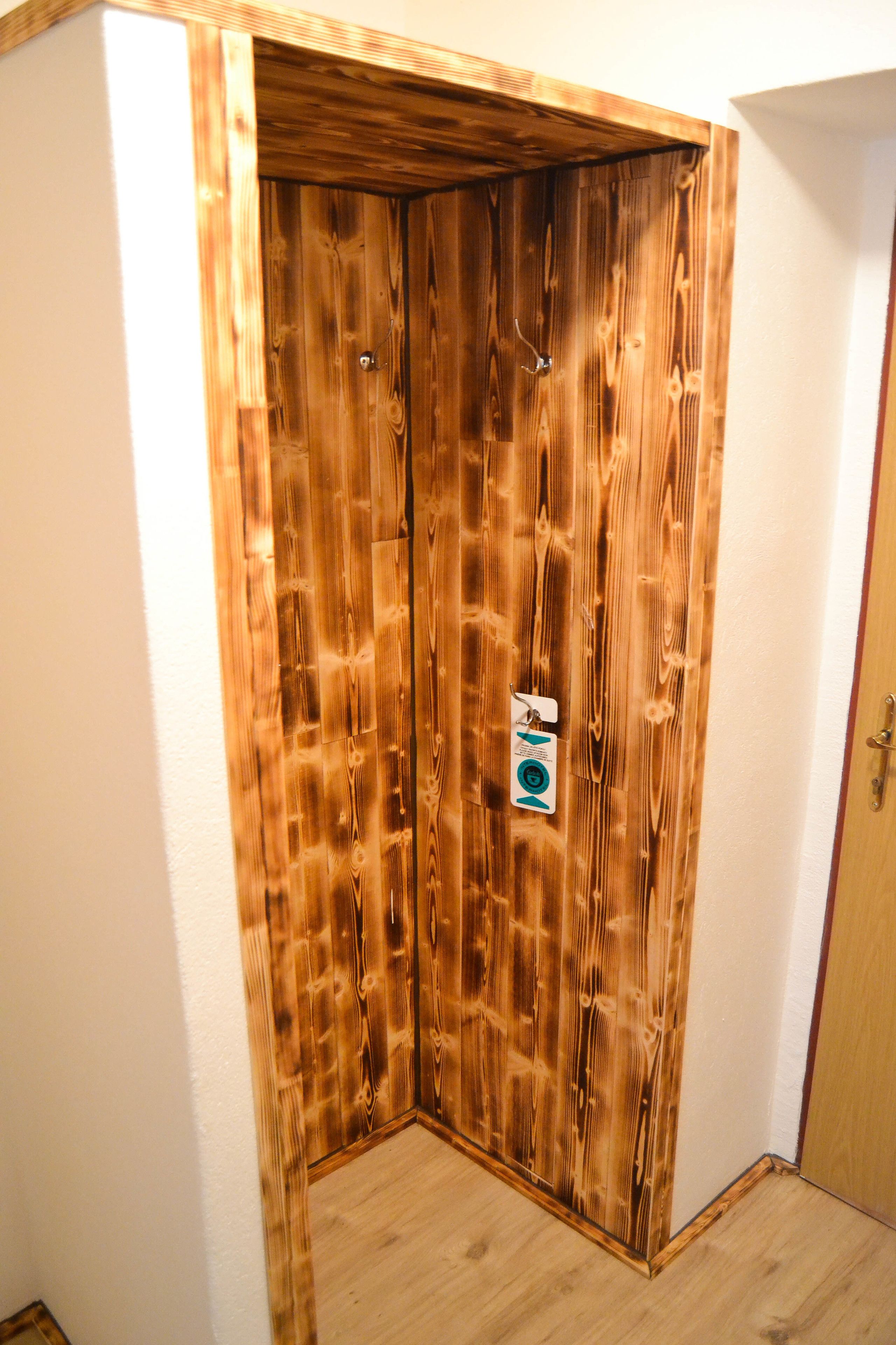 A corner room with a wooden door and a small window.