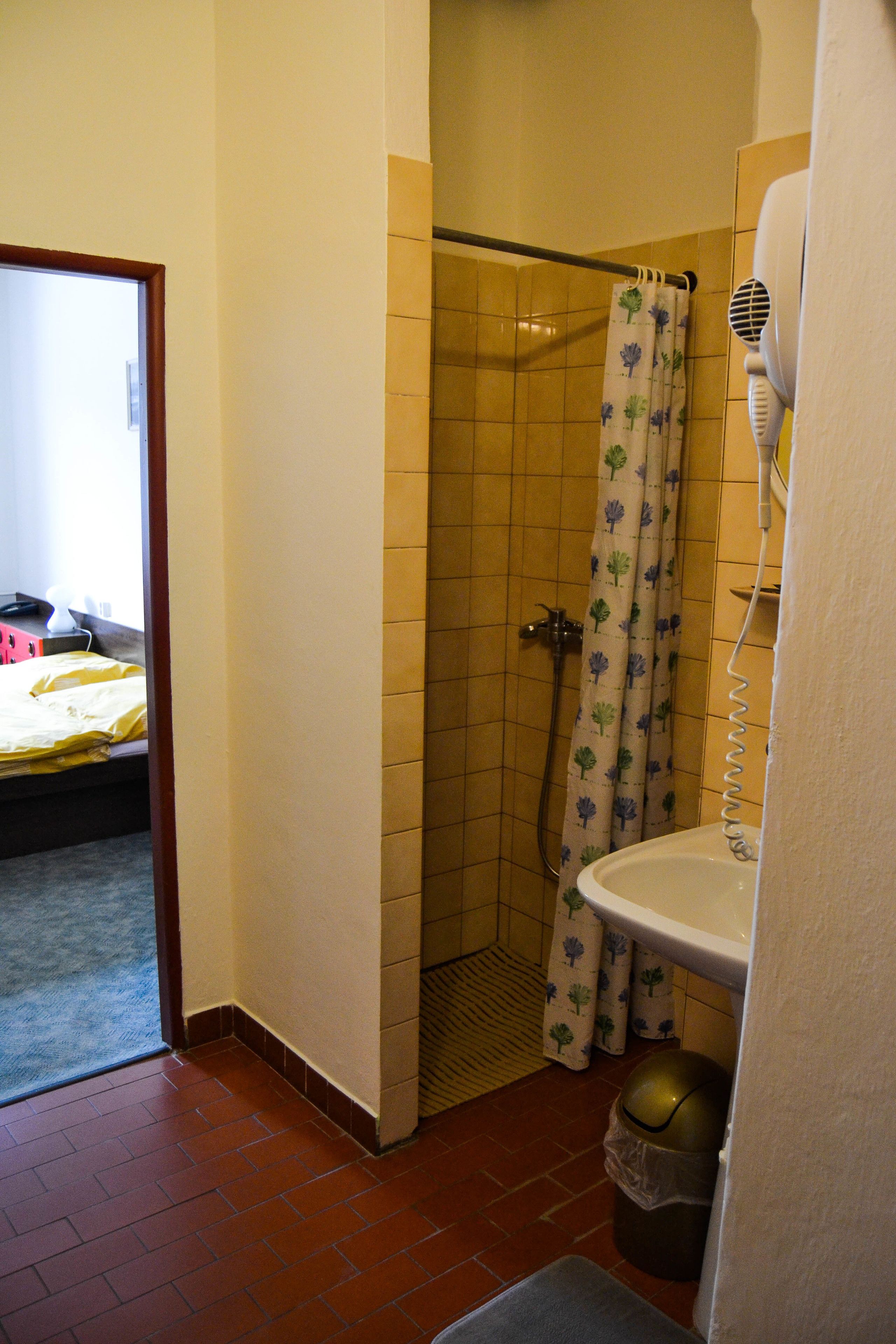 A bathroom with a shower, toilet, and sink.