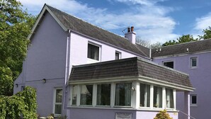 Un bâtiment à deux étages, à la façade violette, doté d’un porche abrité et d’une enseigne indiquant qu’il s’agit d’une maison de retraite.