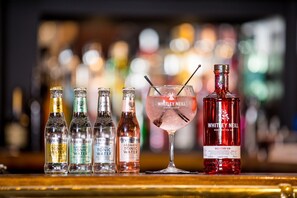 A bar with various bottles and a drink. - Howard Arms (Brampton)