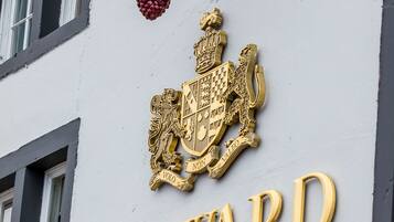 A building facade with a coat of arms and the name "HOWARD ARMS" in gold lettering.