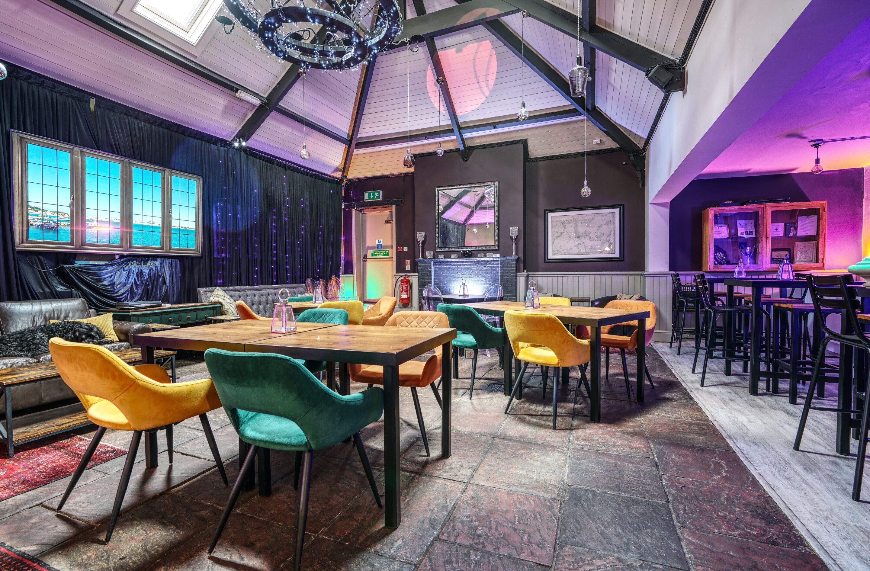 A restaurant with high ceilings, exposed beams, and a mix of indoor and outdoor seating.
