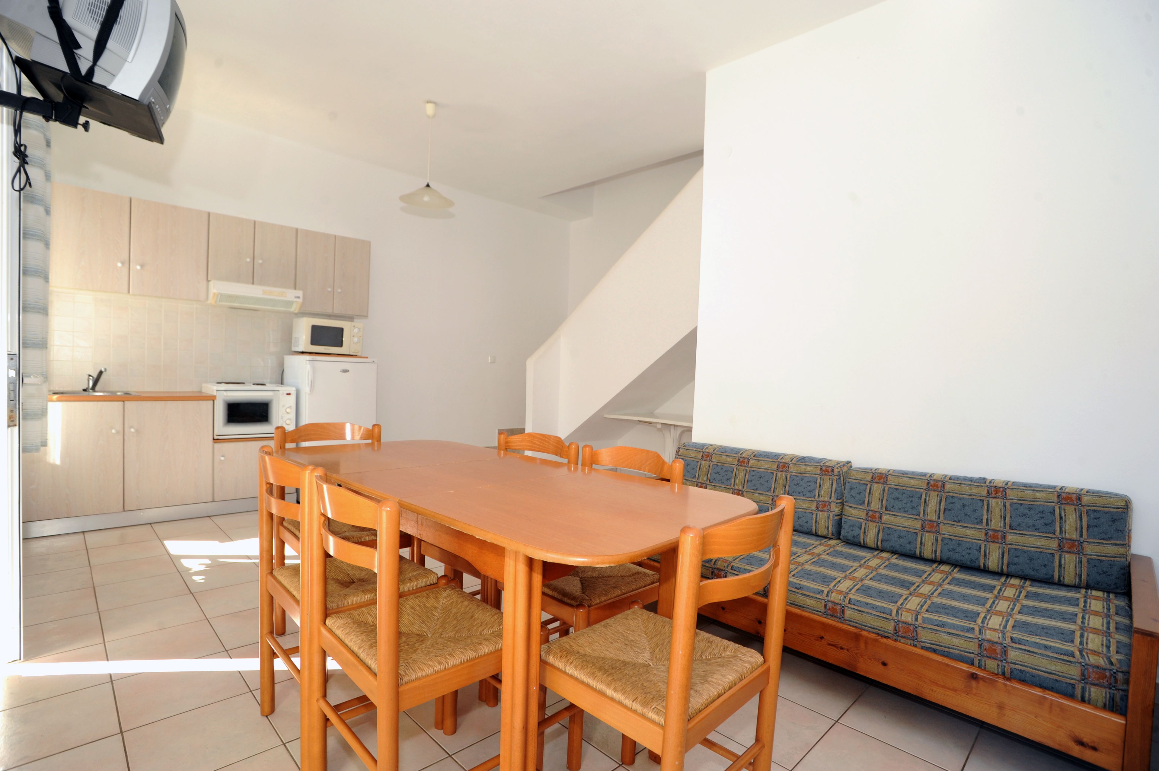 Un espacio habitable compacto con comedor, kitchenette y sofá.