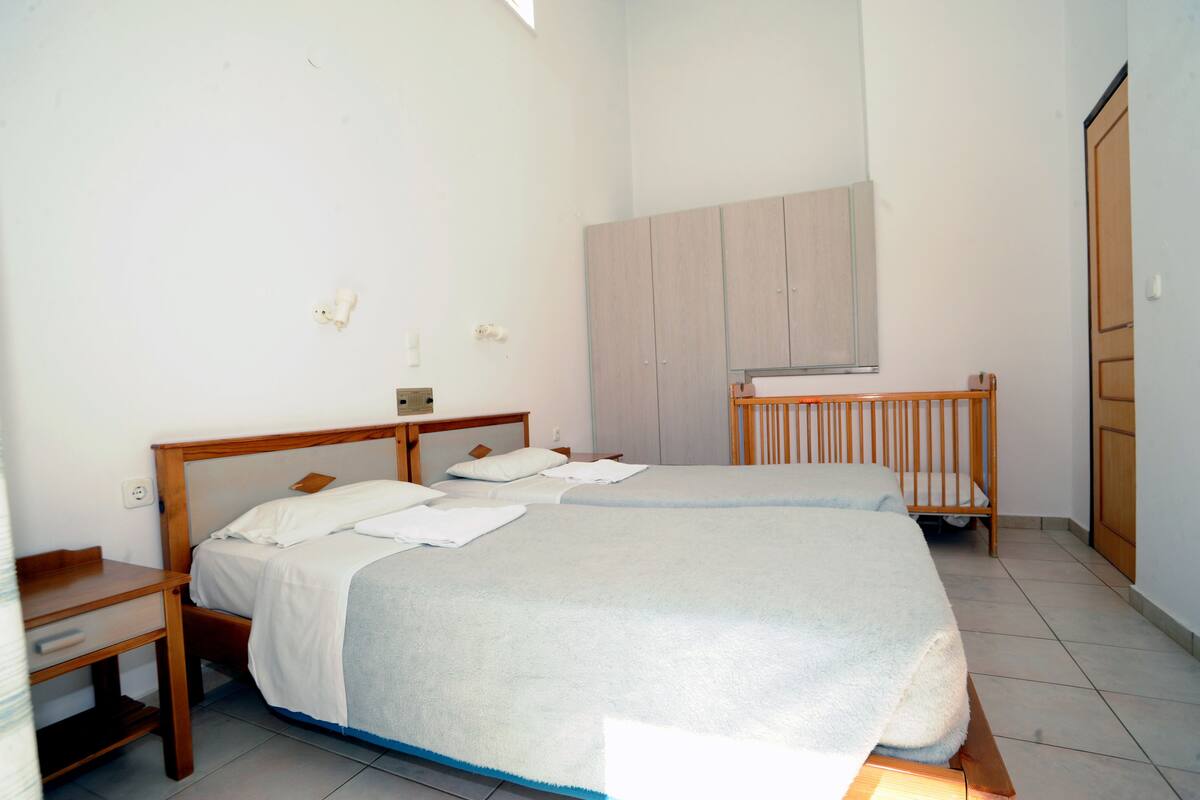 Un dormitorio con dos camas, un escritorio de madera y un armario.