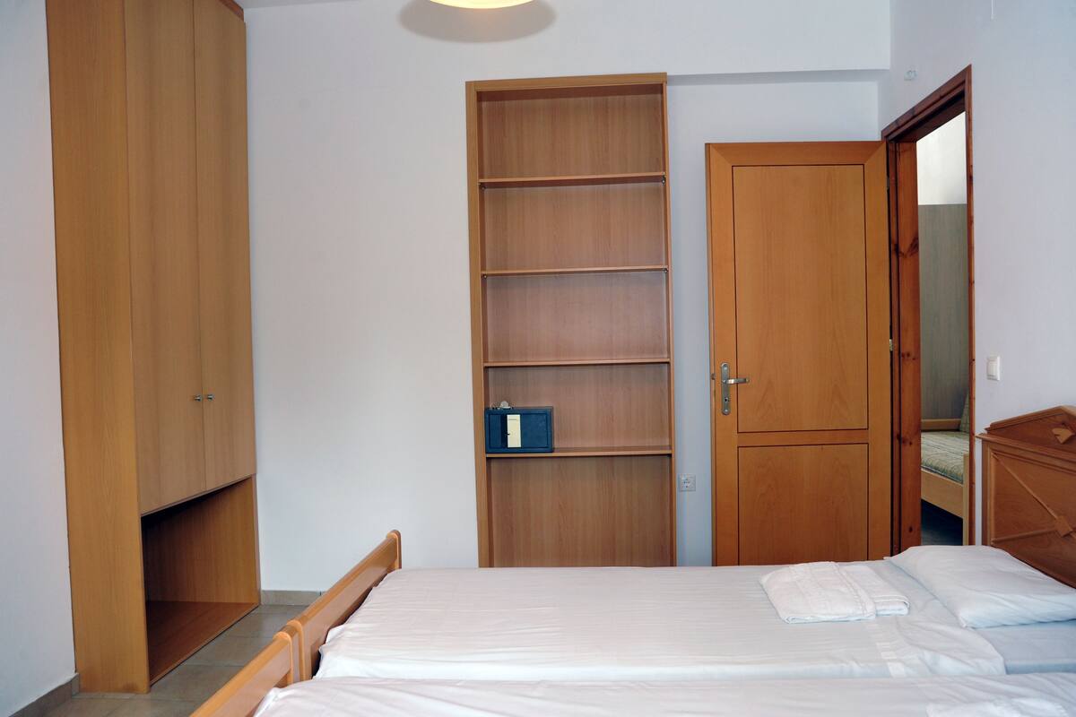 Un dormitorio con una cama, un armario de madera y estanterías empotradas.