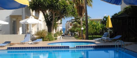 Piscine extérieure, parasols de plage, chaises longues