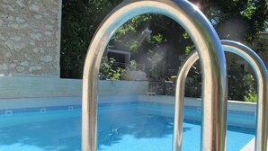 A swimming pool with clear blue water and metal pool ladders. - Loucardalines (Bedoin)