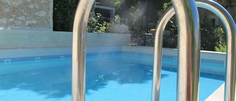 Piscine extérieure, parasols de plage, chaises longues