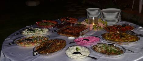 A buffet table with various dishes and utensils.