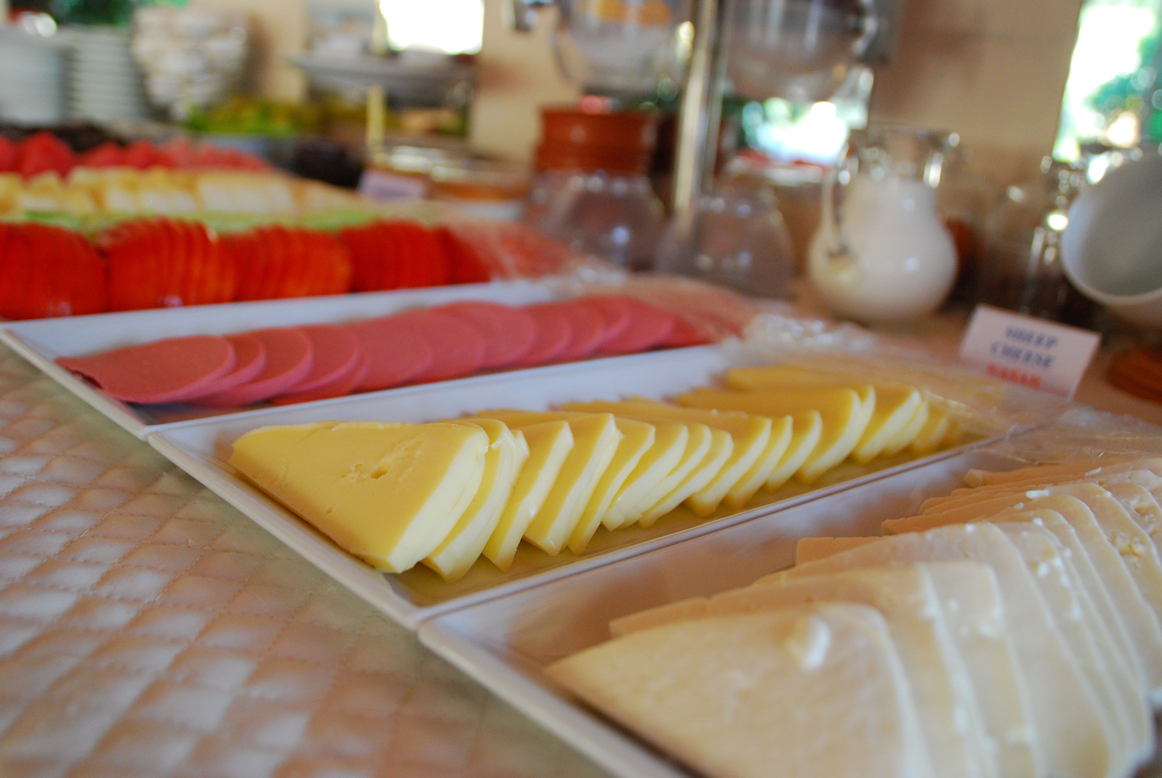 Un buffet proposant une variété de plats, notamment des viandes et des fromages en tranches.