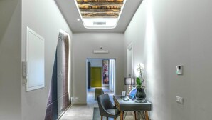 A modern hallway with a skylight, a desk with a laptop, and a chair. - Barberini Luxury (Rome)
