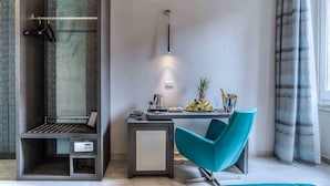 A modern room with a desk, a chair, a hanging light fixture, and a shower area. - Barberini Luxury (Rome)