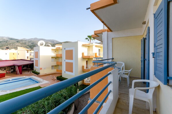 Un immeuble résidentiel doté d’une piscine, de balcons et offrant une vue sur les montagnes.