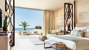 Un dormitorio moderno con una cama grande, vista al mar y un balcón con mobiliario exterior.