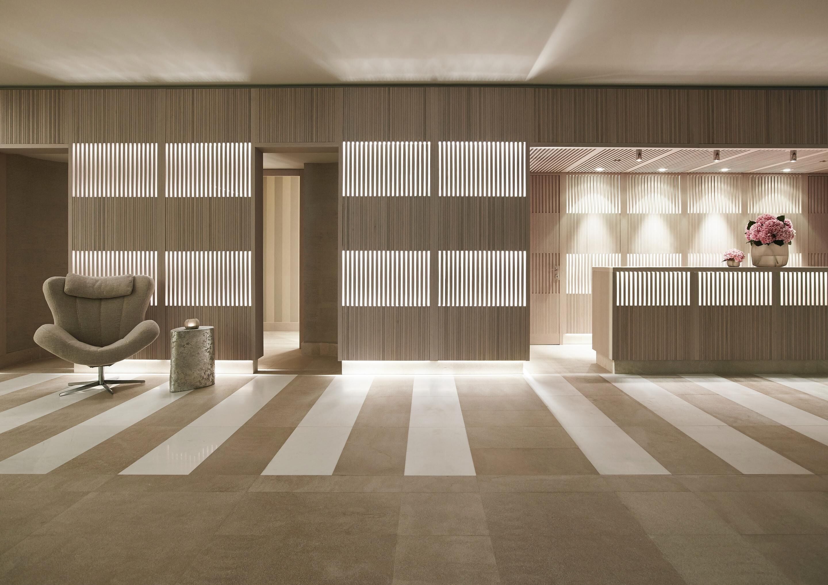 A modern reception area with a reception desk, a seating area with a chair, and a decorative vase.